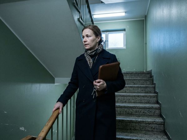 Kiinteistönvälittäjä kävelee ylös rappukäytävässä avaimet kädessä